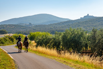 Due cavalieri su una strada verso Capalbio, Grosseto, Toscana, Italia