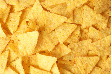 Tasty Mexican nachos chips as background, top view