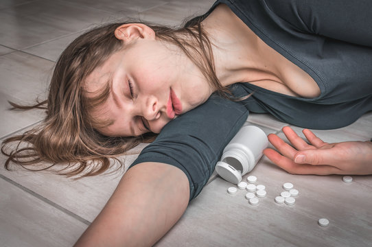 Woman lying on the floor after an overdose of pills