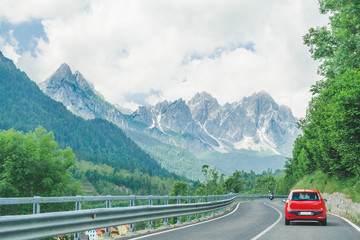 small red car on the road through mountains road trip