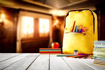 School background with a wooden table top and books and some school supplies.