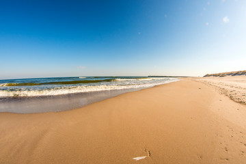 lonesome beach of the Baltic Sea with blue sky and surf