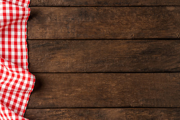 Red checkered tablecloth on wooden background