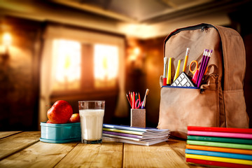 School background with a wooden table top and books and some school supplies. - obrazy, fototapety, plakaty