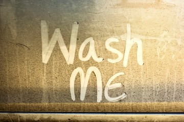 Write the words "wash me" on the very dirty surface of the car. Concept car wash.