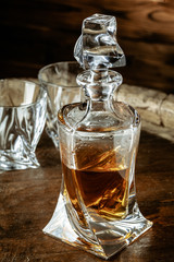Two glasses of brandy or cognac and bottle on the wooden table