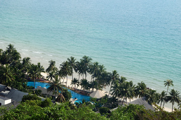 Aerial view of seashore in tropics with palm trees and clear blue sea. Koh Chang, Thailand.