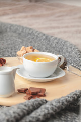 Top view of a cup of tea with lemon piece on wooden table