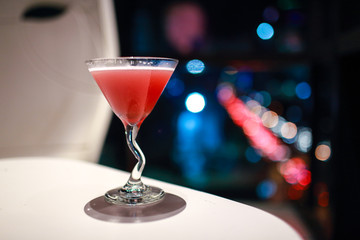 blur image of cocktail glass with city view at night