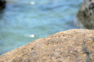 Closeup view of sea stone on a background of blue sea