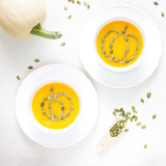 Pumpkin soup with parsley on a white wooden background
