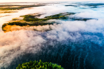 Foggy landscape. Aerial scenery. Blue lakes and green forest view at sunrise