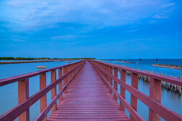 Fototapeta premium Beautiful of The walkway red wooden bridge in evening at Bang Khun Thian sea view, Bang Khun Thian, Bangkok.