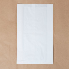 Mock-up of Recycled blank kraft paper shopping white bag for lunch or food or purchases on brown...
