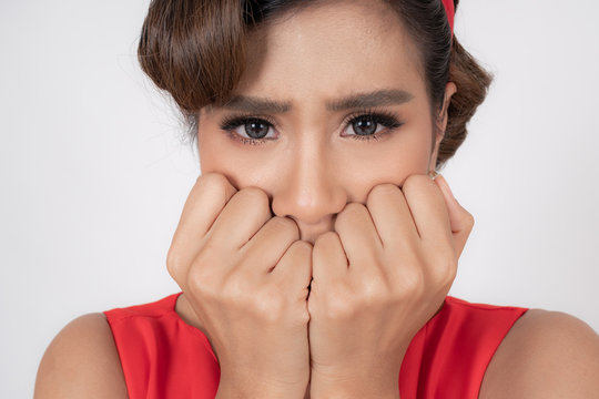 Close up face of pretty Asian woman lift up two hands and gagged by fear, The eyes looking to camera on white background