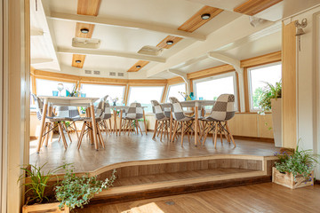 The interior of the urban river ship, with a panoramic view of the urban landscape. The concept of tourism, recreation, walking around the city, rest in the city. River transport.