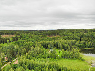 Aerial view of green forest and lake on a summer day in Finland. Drone photography