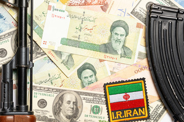 Soviet automaton AK 47 against the backdrop of Iranian money depicting Ruhollah Khomeini and...