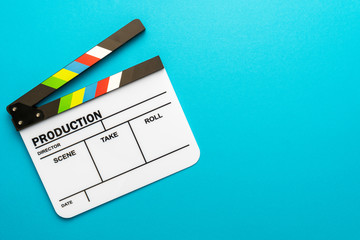 Top view photo of open white clapperboard over turquoise blue background with copy space. Flat lay...