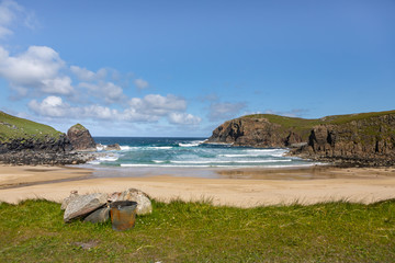 sandy bay with waves crashing onshore on the Isle of Lewis, Outer Hebrides in Scotland on a sunny...