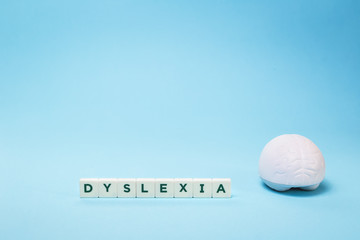 Dyslexia word with a brain stress relief on blue background, reading difficulty and disorder visual and auditory memory or test concept. Education and neurology with copy space
