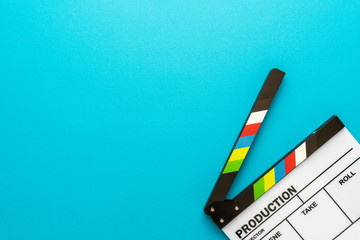 Top view of open white acrylic clapperboard over turquoise blue background with copy space....