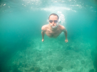 Naklejka premium Young man swimming in blue water in the ocean