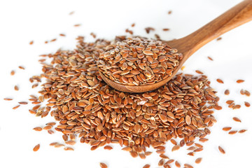 Brown flax seed in spoon on white background.