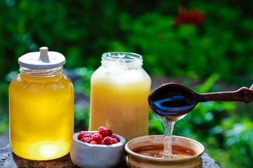 fresh sweet honey dripping in a wooden spoon in a ceramic bowl