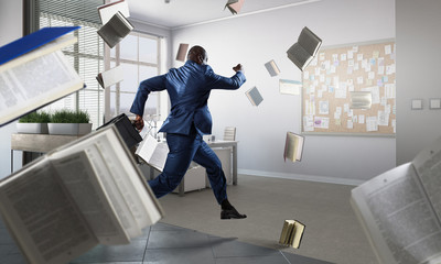 Running black businessman with briefcase