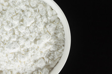 white flour in bowl cooking on black background.