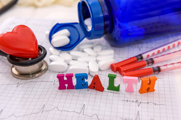 Bottle with pills and syringes on cardiogram