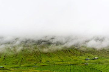 Green mountain covered with a morning fog. Streymoy island, Faroe.