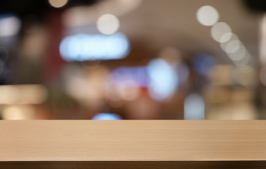 Empty dark wooden table in front of abstract blurred bokeh background of restaurant . can be used for display or montage your products.Mock up for space.