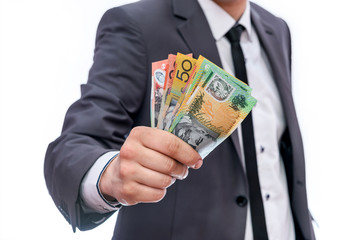 Businessman showing fan of australian dollar banknotes