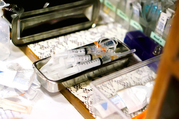 Vaccine in plastic syringes in medical stainless steel container for ready injection to patient.