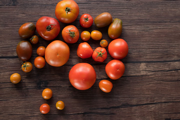 Fototapeta na wymiar Ripe fresh organic tomatoes on a brown wooden table.