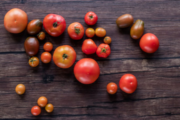 Ripe fresh organic tomatoes on a brown wooden table.