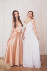 Fototapeta premium advertising of fashion for woman: dress, shoes. two happy girls smiling. Portrait of women hugging. The concept of relationships in the family, friends, sisters, couple in love. isolated on white back