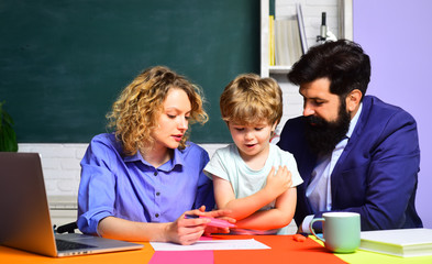 Pupil learning letters and numbers. Mother father and son together schooling. Little boy and his parents. Education concept. Happy family. Education for kids out of school. Boy from elementary school.