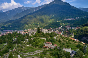 Fototapeta premium Aerial photography, castle of Breno in the province of Brescia, Lombardy region. The castle is located on a mountain surrounded by the Alps in the background the city of Breno in the north of Italy.