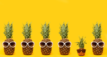 Series of pineapples in sunglasses on a yellow background