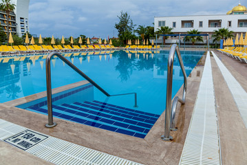 blue swimming pool with yellow loungers
