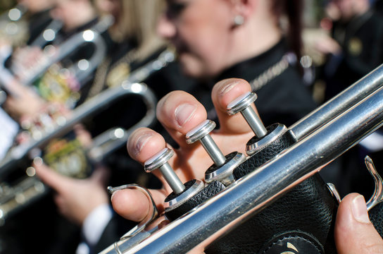 Macro en los dedos de un m&uacute;sico tocando la trompeta durante la Semana Santa en Sevilla, Espa&ntilde;a