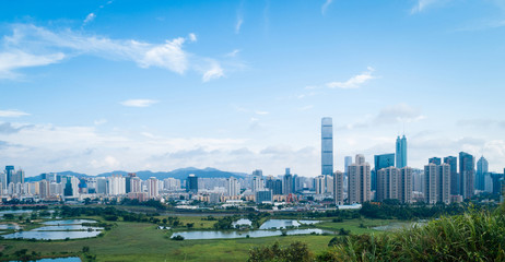 Naklejka premium Rural green fields with fish ponds between Hong Kong and skylines of Shenzhen,China