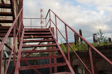 Metal brown stairs to blue sky with chimneys background