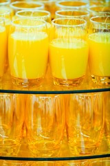 Orange glass cups full of orange juice.