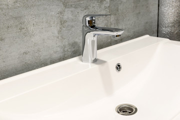 Bathroom interior with white sink and faucet, copy space. Contemporary minimalist washbasin