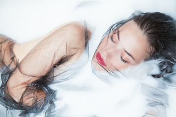 dreaming in milky bath beautiful woman portrait with black tulle in milk