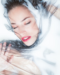 sensual woman creative portrait with black tulle in milk bath